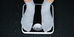 다양한 체중 감량 보조 용품이 함께 놓여있는 모습으로 덤벨, 요가 매트, 스마트 스케일 등이 보임